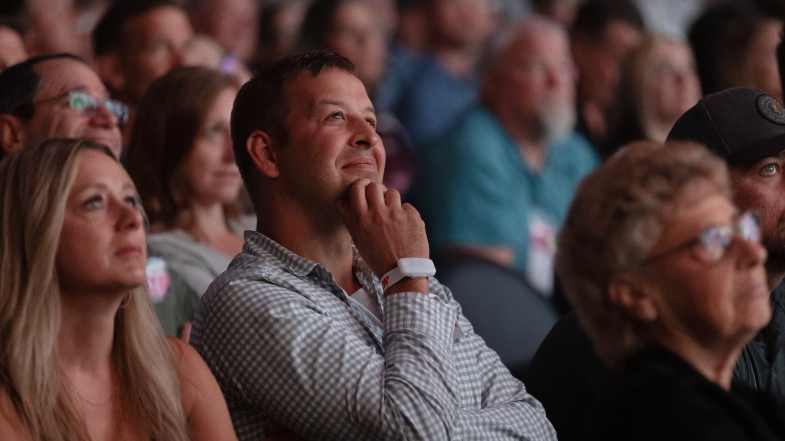 Audience members listening intently during a live presentation.